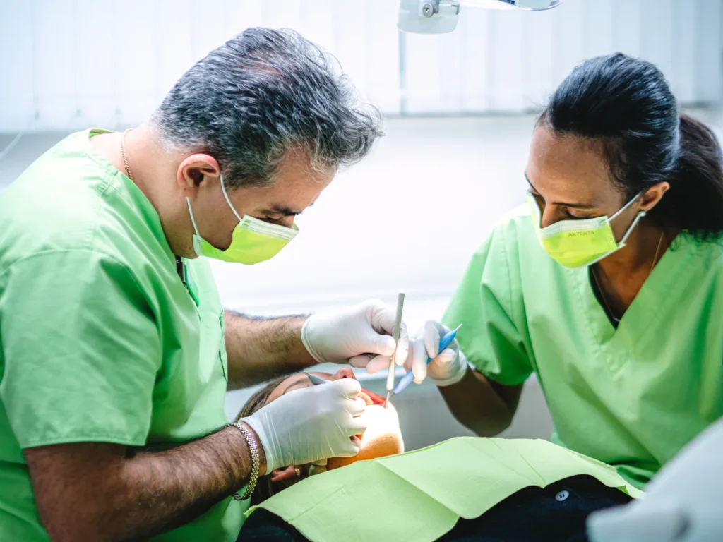 Tandläkare och tandhygienist under pågående tandläkarbehandling